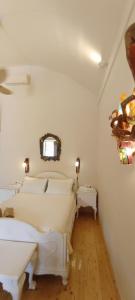 a bedroom with two beds and a mirror on the wall at Aliori art caves in Aegiali
