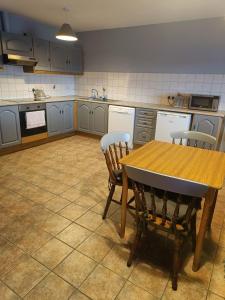 a kitchen with a wooden table and two chairs at Dingle Town Center Apartment in Dingle
