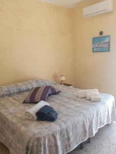 a bedroom with a bed with two towels on it at casa vacanza luminosa fava in Floridia