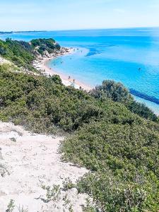 Una playa con gente en la arena y el océano. en Cosega Luxury Villa #PROPERTLY, en Nea Kalikratia