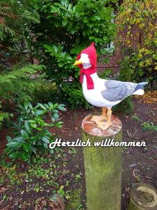 a statue of a chicken sitting on a stump at Luett Huus in Eckernförde