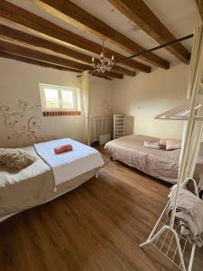 two beds in a room with wooden floors at Le Val de Nodicia in Montlivault +27 photos