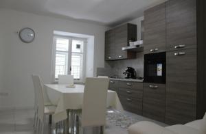 a kitchen with a white table and white chairs at Residenza Villa Gorìa in Pontestura