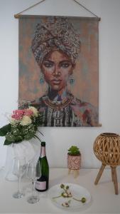 a painting of a woman on a wall with wine glasses at Mykonos Townhouse Gem in Mýkonos City