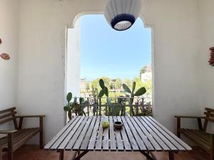 a wooden table in a room with a large window at Appartamento Marina in Tropea