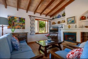 a living room with a blue couch and a table at Villa Ca Na Magdalena By homevillas360 in Pollença
