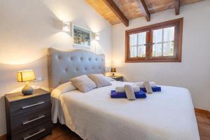 a bedroom with a large bed with blue pillows at Villa Ca Na Magdalena By homevillas360 in Pollença +31 photos