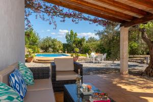 a patio with a table and chairs and a swimming pool at Villa Ca Na Magdalena By homevillas360 in Pollença