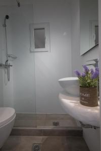 a bathroom with a toilet and a sink and a shower at Mykonos Townhouse Gem in Mýkonos City +18 photos