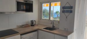 Una pequeña cocina con fregadero y ventana. en Apartamento en Salou-Vistas al Mar, en Salou
