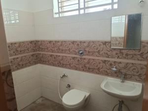 a bathroom with a toilet and a sink at Royal Home Stay Mysuru - Service Apartment in Mysore