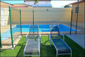 zwei Stühle vor einem Pool in der Unterkunft Bungalow Curro Pareja 131 in Conil de la Frontera