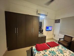 a bedroom with a bed and a cabinet with red pillows at Green rooms in Bhopal
