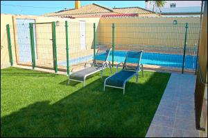 zwei Stühle vor einem Pool in der Unterkunft Bungalow Curro Pareja 131 in Conil de la Frontera