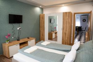 a hotel room with two beds and a television at Orchidea apartman in Makó
