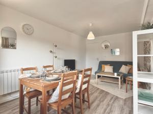 una sala da pranzo e un soggiorno con tavolo e sedie di Charmant T3, Parking & Wi-fi, Cuisine équipée a Villers-sur-Mer
