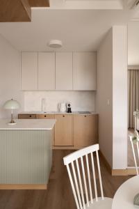 a kitchen with white cabinets and a table and chairs at Piwna Apartamenty nad morzem Władysławowo in Władysławowo
