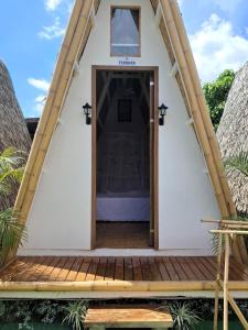 eine Tür zu einem winzigen Haus mit Veranda in der Unterkunft Happy Monkey Hostel in El Nido