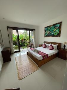 una camera da letto con un letto e una grande finestra di Nugraha Guesthouse 1 ad Ubud