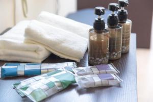 a bow tie and two bottles of soap and towels at Condominium Hotel Monpa in Chatan