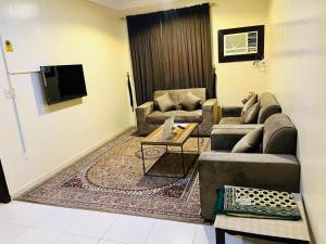 a living room with two couches and a tv at العييري للشقق المخدومة الدمام 8 in Dammam