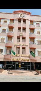 Un gran edificio con un reloj encima. en Apartments Hadaiq AL Khalij For Serviced Apartments شقق حدائق الخليج للشقق المخدومه, en Dammam