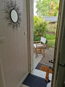 eine Tür, die zu einer Terrasse mit einem Spiegel führt in der Unterkunft Chambre Indépendante "Terre Rouge" in Martignas-sur-Jalle