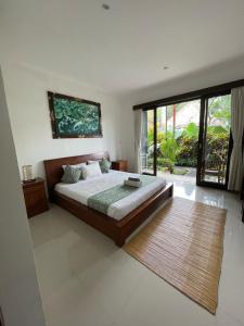 una camera da letto con un letto e una grande finestra di Nugraha Guesthouse 1 ad Ubud