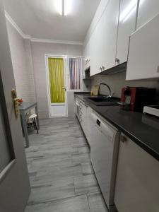 a kitchen with white cabinets and a tile floor at Vivienda La Manola in Daimiel +9 photos