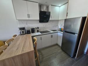 a kitchen with a wooden table and a refrigerator at Mountain View Retreat in Flic-en-Flac