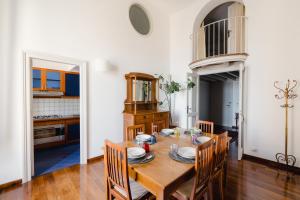 a kitchen and dining room with a wooden table and chairs at Charming Sea View Loft by Mare&Dimore in Trapani