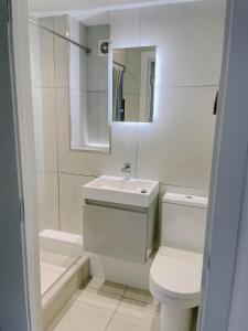 une salle de bains blanche avec toilettes et lavabo dans l'établissement Cosy 1 bedroom Cottage - Great location & Parking, à Penzance