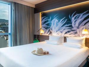 a hotel room with a bed with a hat on it at Novotel Barcelona City in Barcelona +37 photos
