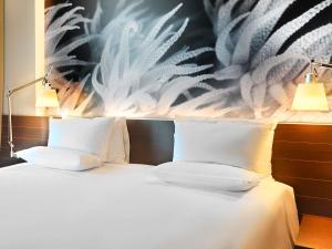 a bedroom with a bed with two white pillows at Novotel Barcelona City in Barcelona