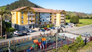 an aerial view of a parking lot with a yellow building at Apartamentos Liérganes Centro in Liérganes