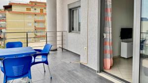 balcón con mesa, sillas y TV en Plutus Sea View Apartment, en Sarandë