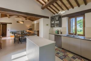 a kitchen with a counter and a dining room at Villa Anna heated pool two outdoor jacuzzi and sauna in SantʼIppolito
