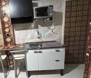 a kitchen with a sink and a microwave at Espaço para duas pessoas, 5 minutos do centro de Sao Bernardo do Campo in São Bernardo do Campo