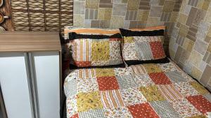 a bed with a quilt and pillows on it at Kitnet 5 minutos do centro de Sao Bernardo do Campo in São Bernardo do Campo