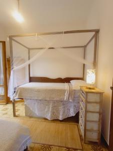 a bedroom with a canopy bed and a night stand at Casa Artigena in Rapallo