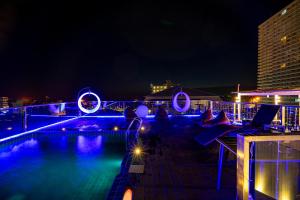 a swimming pool at night with a laptop on the deck at HT9 Hotel in Jomtien Beach