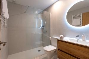 a bathroom with a toilet and a sink and a mirror at Apartamentos Liérganes Centro in Liérganes +47 photos