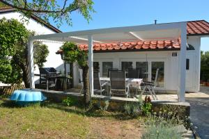 a pavilion with chairs and a table in a yard at Sunny Cottage in Petrcane