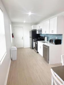 a kitchen with white cabinets and stainless steel appliances at Shore Thing in Wildwood