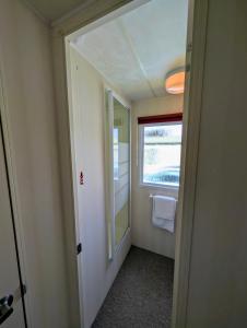 Isle of WightにあるBembridge Hideaway Static Caravan - Sandhills Holiday Park with Private Beachのバスルーム(鏡、窓、ドア付)