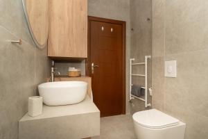 Un baño con un lavabo blanco y un inodoro. en Elaia Boutique Apartment, en Pylos 17 fotos más