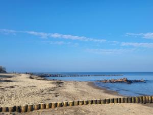 a sandy beach with a pier in the water at kleines feines Kühlungsborn, Studio mit Terrasse, Parkplatz & WLAN, 300m vom Strand entfernt in Kühlungsborn