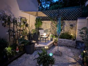 a garden at night with an umbrella and plants at L'appartement Paulange in Laprade