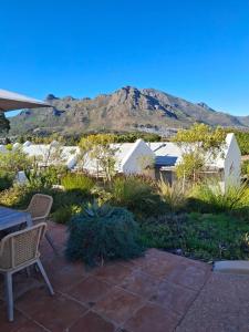 a patio with a table and chairs and a mountain at Umoya Residence in Cape Town