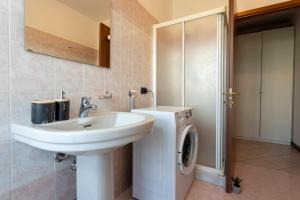 ein Badezimmer mit Waschbecken und Waschmaschine in der Unterkunft Novara Smart Stay - Station, AC & 2Gb s Wi-Fi in Novara + 18 Fotos